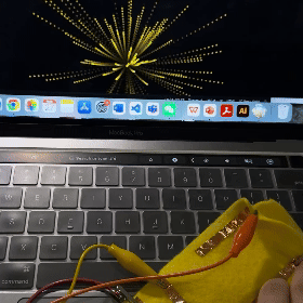 The gif shows my hand actively pressing the copper tape strips on the fabric, which causes dynamic visual effects on the laptop screen. Each touch creates a vibrant explosion of colors, demonstrating the interactive and fun nature of using Makey Makey to connect everyday materials with digital technology.